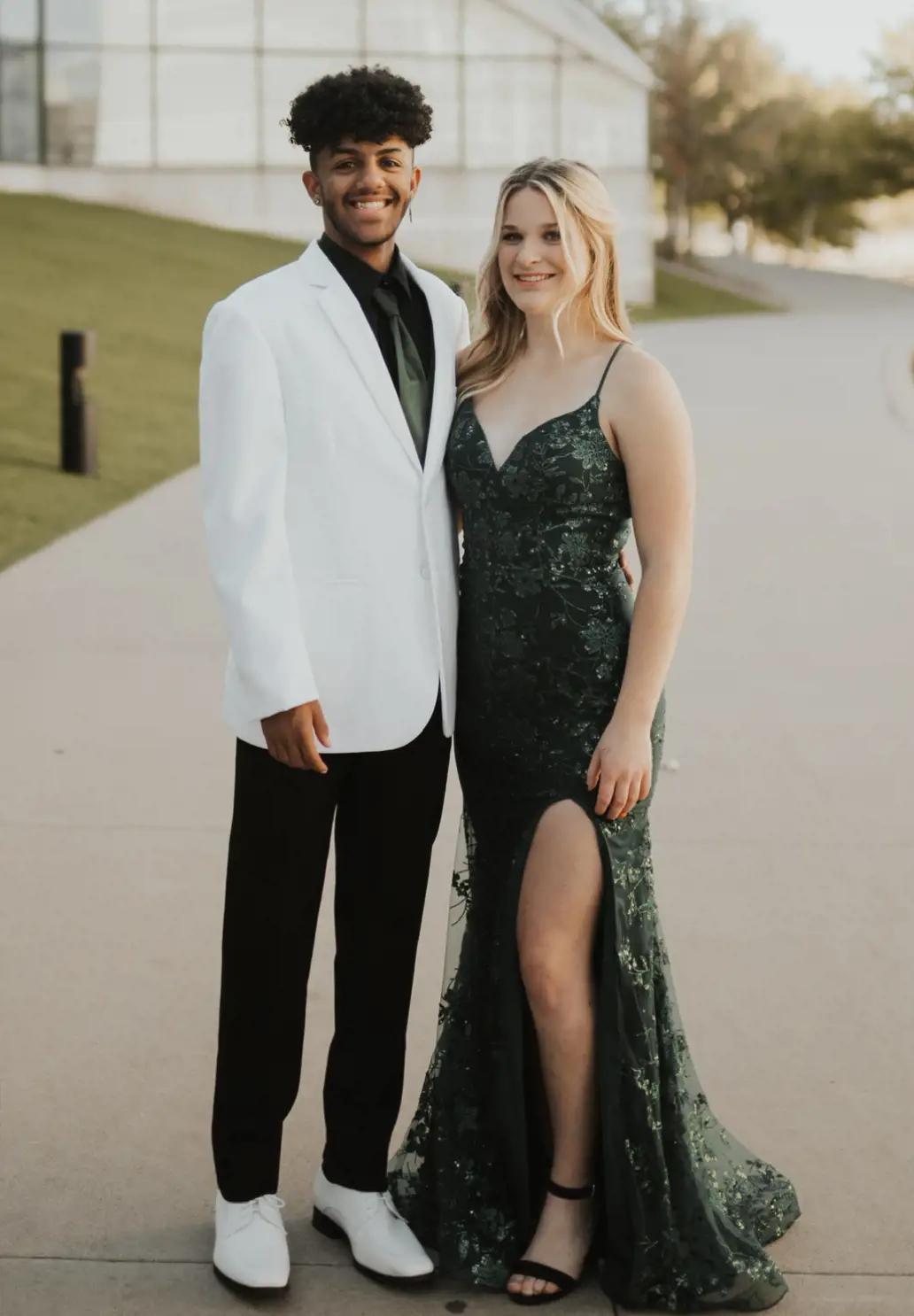 prom boy wearing a black suit and a prom girl wearing an emerald green gown